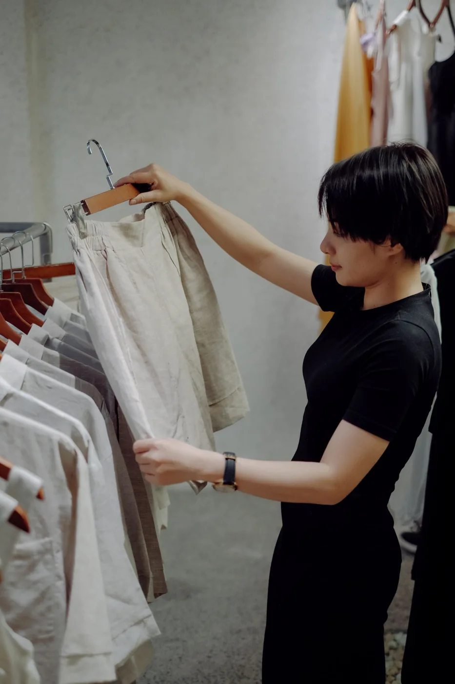 Woman examining a pair of shorts in a clothing shop